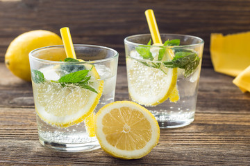 Lemonade or mojito cocktail with lemon and mint with ice. Cold summer refreshing drink decorated with yellow napkin