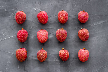 Lychee fruits pattern on grey background flat lay top-down