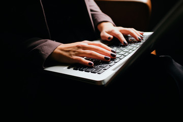Close up photo of hands typing on laptop keyboard