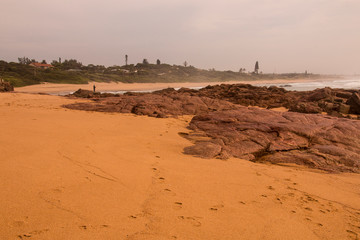 Sand and Rocks Line the Seashore