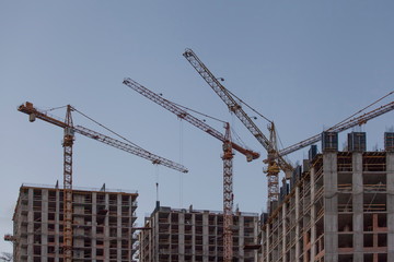 construction site with cranes against the blue sky