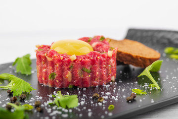tartar with yolk on a white wooden background