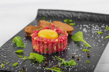 tartar with yolk on a white wooden background