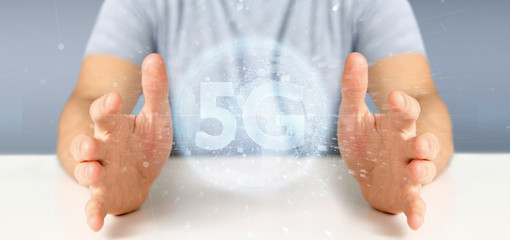 Fototapeta premium Businessman holding a 5G connection with data surrounding - 3d rendering