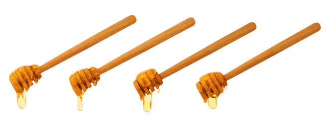 Bee honey drops and wooden sticks isolated on white background with clipping path. Healthy natural food ingredient. Apitherapy, alternative medicine.