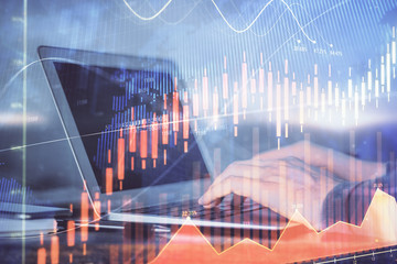 Double exposure of stock market graph with man working on laptop on background. Concept of...