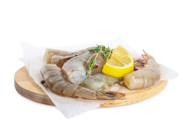 Wooden board with raw shrimps, lemon and thyme isolated on white