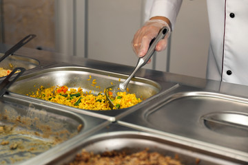School canteen worker at serving line, closeup. Tasty food