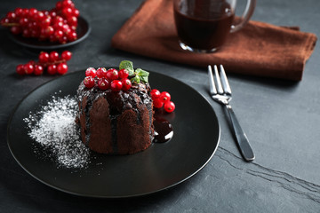 Fototapeta na wymiar Delicious warm chocolate lava cake with mint and berries on dark grey table