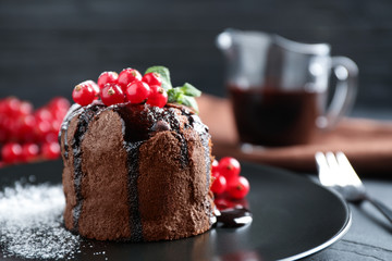 Delicious warm chocolate lava cake with mint and berries on table, closeup. Space for text
