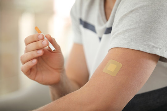 Man with nicotine patch and cigarette, closeup