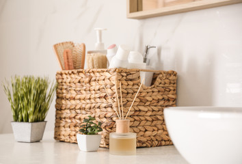Different toiletries and green plants on countertop in bathroom