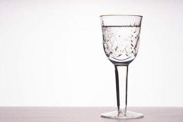 a glass of vodka on the table on a white background, tinted image, selective focusing, vignetting
