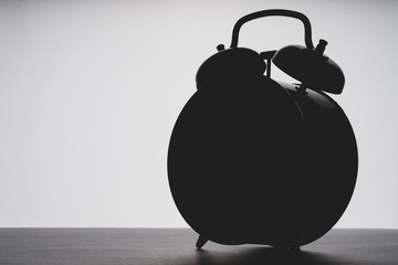 outline of the alarm clock in the dark, toning, selective focus, space for text on the left