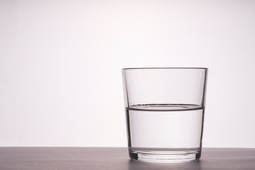 glass of water on the table, toning, selective focus, space for text on the left, white background