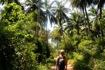 Fototapeta na wymiar man hiking with a backpack through jungle in thailand on nature path