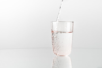 Pouring cristal cleen water into glass, close up