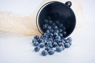 A bunch of ripe blueberries on a blue background copy space.