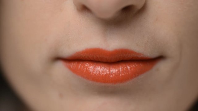 Red lips kissing. Kiss of an young woman. Close-up.