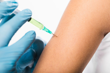 Close-up individual being vaccinated for virus