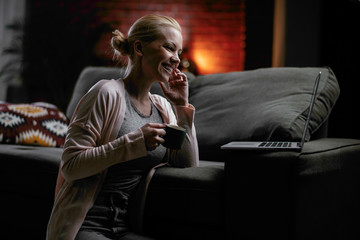 Young woman at home. Beautiful woman sitting in living room watching movie.	