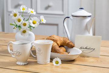 Table With Croissants And Envelope With German Word For Invitation