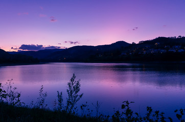 purple sky at sunset over mountain lake. panoramic landscape, twilight sky