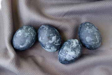 Background with easter eggs. Naturally dyed eggs prepared for Easter on gray texture tablecloth background. Happy Easter