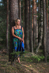 woman in the woods on the road and by the tree, fresh air summer vacation, medical walks at the resort, sanatorium recreation