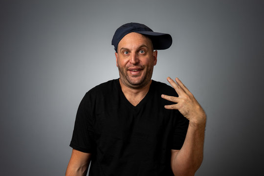 man in black vneck teeshirt and backwards hat