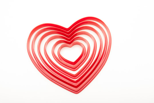 Concentric group of red heart shapes nestled together on a white background