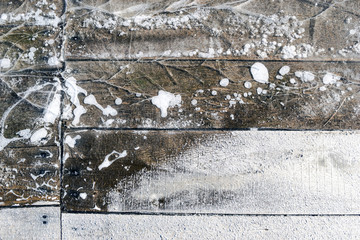 Wooden planks covered with ice on the frozen river background