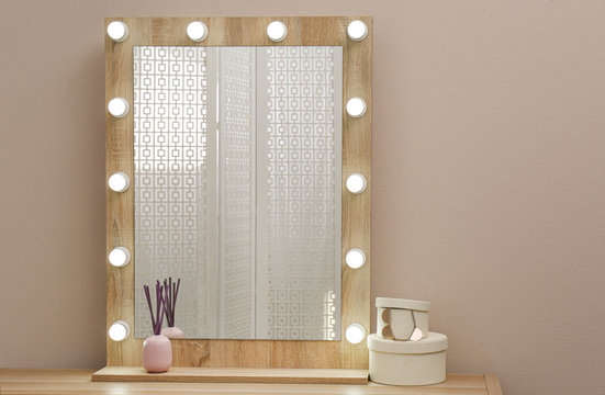 Stylish Mirror With Light Bulbs Near Beige Wall