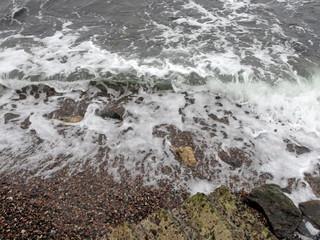 Landscape of waves on the stormy surface of the Black Sea breaking and rising on the sandy coast.