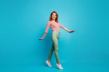 Fototapeta na wymiar Full body profile photo of funny lady enjoy warm spring day spend active time walk street wear casual red white pullover green pants footwear isolated blue color background