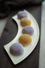 Multi-colored Japanese Mochi in rice dough and on a wooden background. Traditional Japanese dessert.