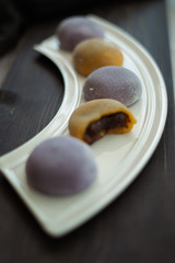 Multi-colored Japanese Mochi in rice dough and on a wooden background. Traditional Japanese dessert.