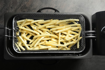 Cooking delicious french fries in hot oil, top view