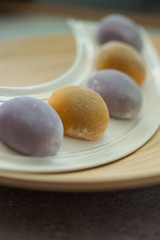 Japanese Mochi in rice dough and on a beautiful bamboo plate and concrete background. Traditional Japanese dessert.
