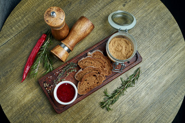 Fresh homemade Goose liver pate with rye bread and jam on wooden tray. Top view on tasty restaurant food. appetizer