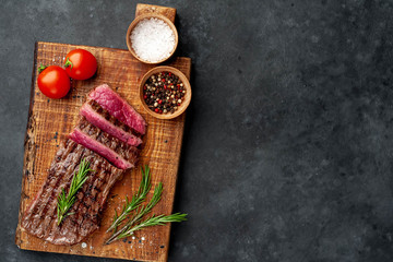 Obraz na płótnie Canvas grilled beef steak with spices on a stone background