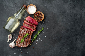 grilled beef steak with spices on a stone background