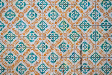 Ornate orange and teal tiles on a building in Lisbon, Portugal