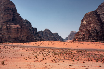 Panoramic view of rocky mountains and red sand in the Jordanian desert of Wadi Rum.