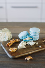 Cheese and walnuts with chalkboard macaron on wood board