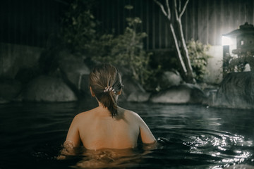 Fototapeta premium Lady wear notthing in Onsen hot spring water in Yufuin, Japanese onsen in Oita, Japan