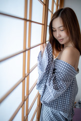 Sexy girl wearing Yukata on lower body and nude on upper with lonely face in Japanese tatami room...