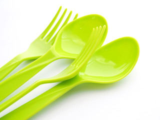 Green plastic spoon and fork isolated on white background