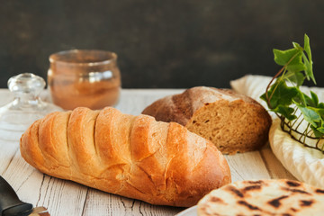  Fresh golden loaf of bread on a white wooden table