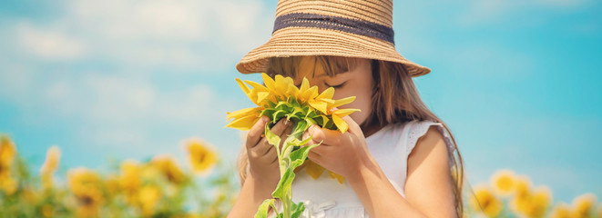 A child in a field of sunflowers. Selective focus.